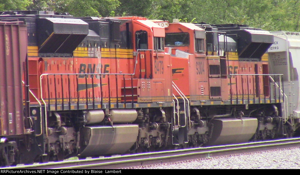 BNSF units sandwiched by cars